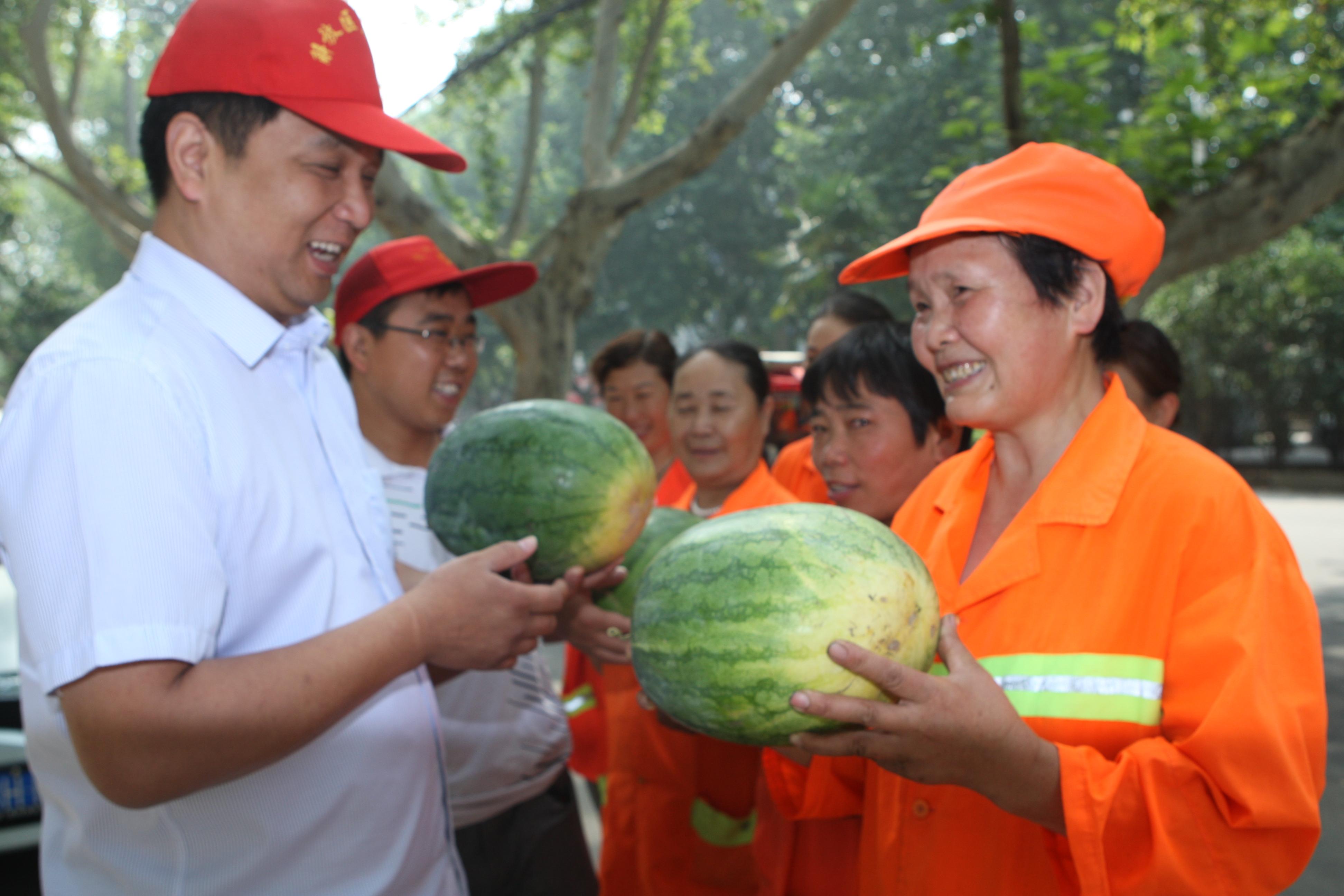 图片新闻:环卫工人冒酷暑保洁 党员干部一线送